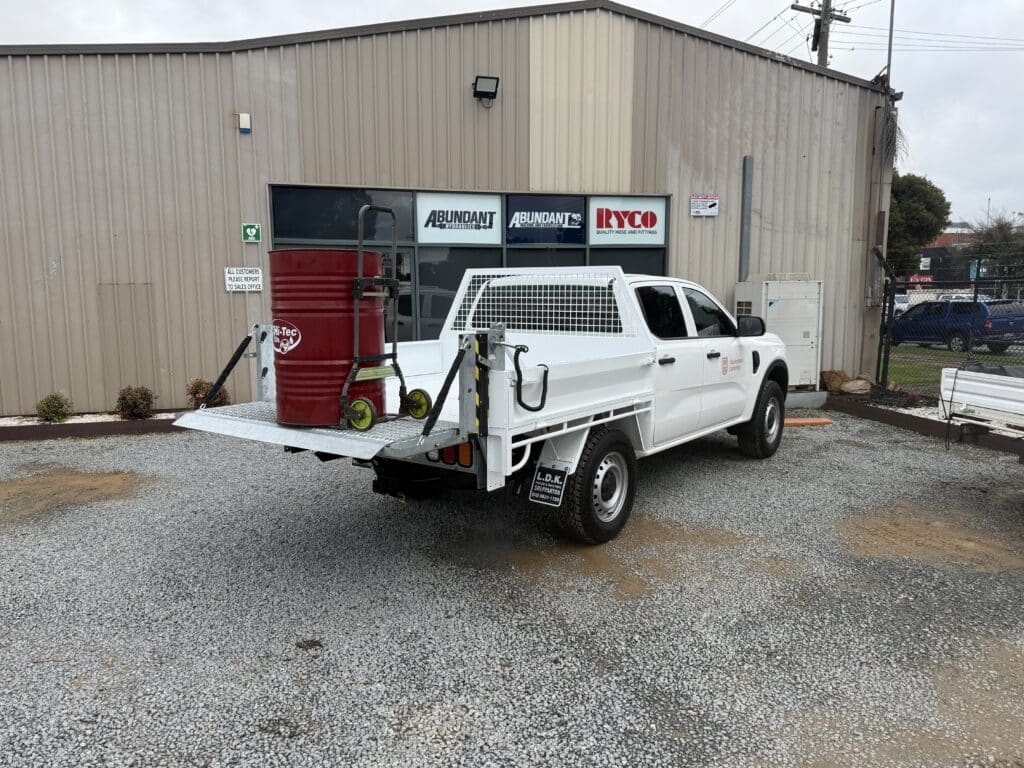 Tommy Gate installed on ute; drum on top.